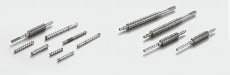 Threaded, stepped and grooved precision shafts on a light background