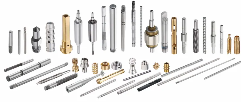 Assortment of precision shafts, pins, sleeves and turned parts on a white background